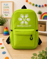 A bright lime green backpack with black straps and a white printed logo of handprints forming a sprout and the text 'SkillSprouts OT' on the front pocket, displayed on a wooden floor in a decorated children's room.